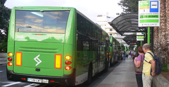 Varios usuarios del transporte público esperan en una parada de autobús de la empresa TITSA.