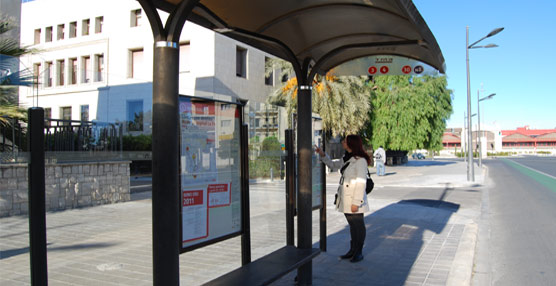 Una usuaria consulta los horarios de autobuses en una marquesina de EMT Valencia.