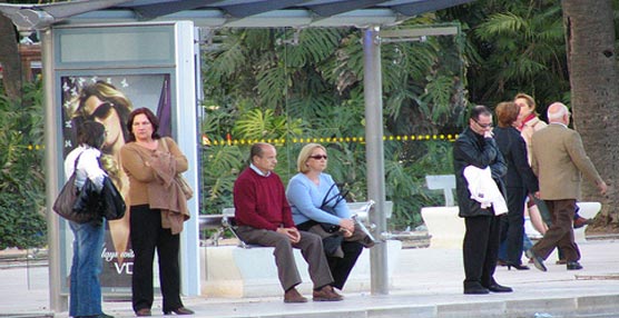 Varios usuarios mayores de 60 años esperan en una parada de autobús.