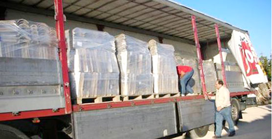 Unos transportistas comprueban su carga de pales.