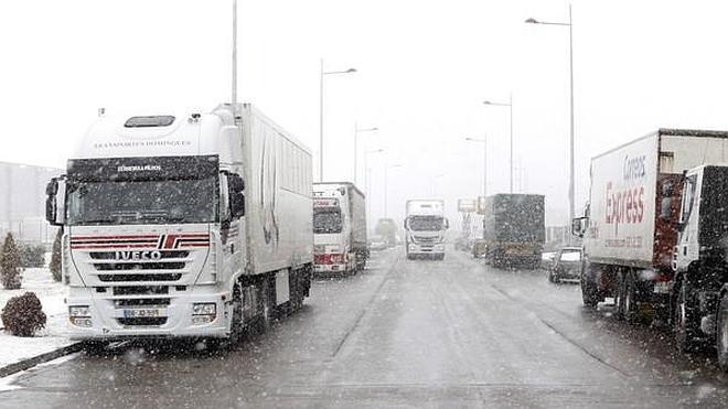 Camiones en una carretera nevada.