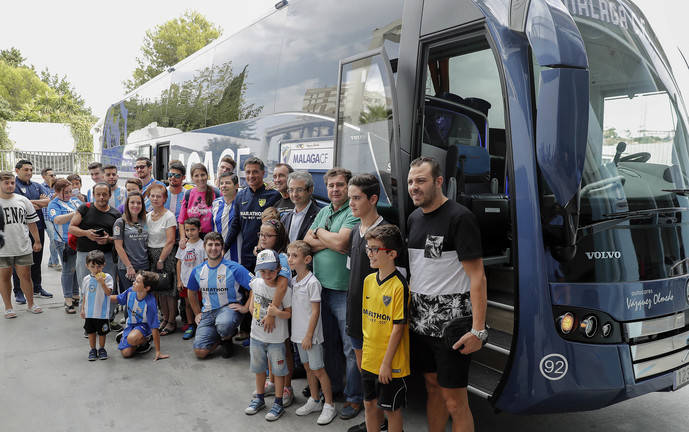 El entrenador del Málaga, Míchel, junto al autocar del equipo y varios aficionados.