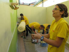 Miembros de DHL pintando instalaciones de la Asociación de Desarrollo e Intervención Abrazo Adi
