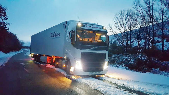 Un camión de Orcelitrans en una carretera nevada.