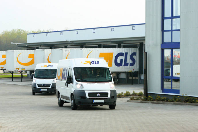 Dos furgonetas de GLS salen de un almacén logístico de la compañía.