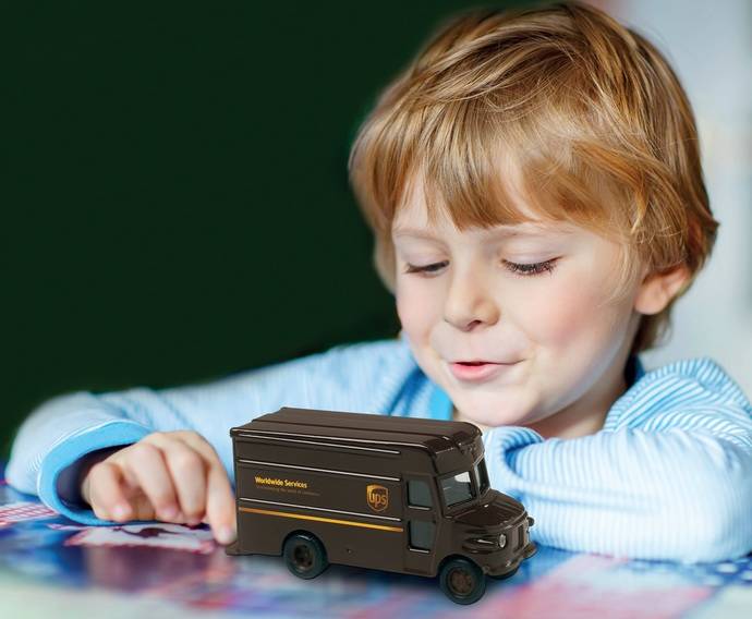 Un niño juega con una maqueta a escala de la mítica furgoneta de repartdo de UPS.