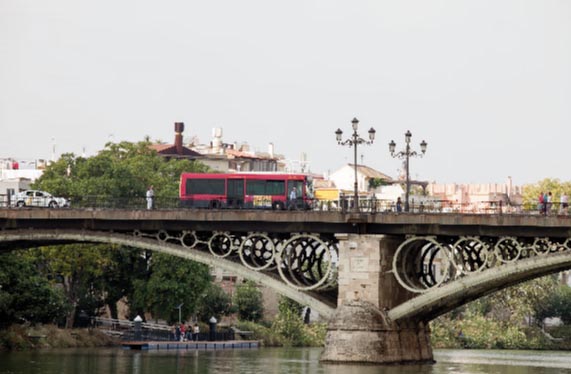 Un autobús de Tussam recorre uno de los puentes de la ciudad de Sevilla.