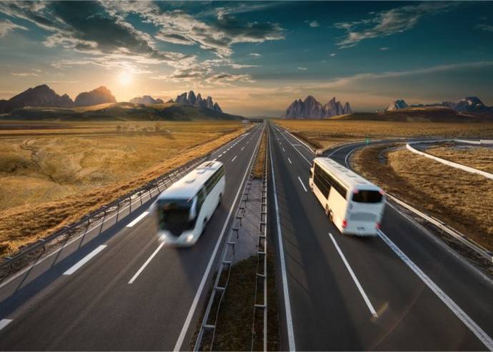 Un autocar circula en cada dirección por una autopista.