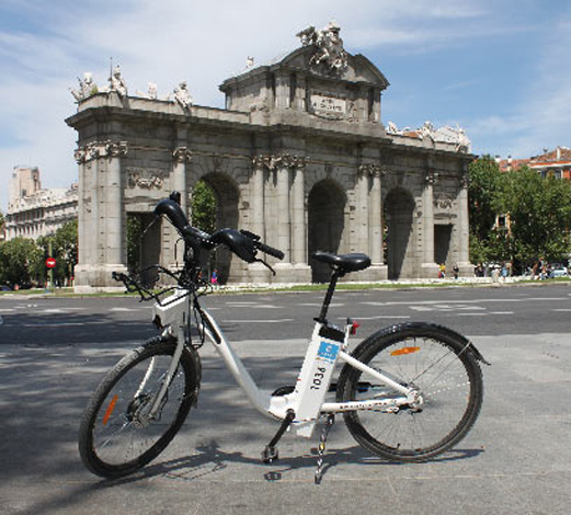 Una bicicleta de BiciMAD, junto a la famosa Puerta de Alcalá de la capital.
