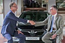 Los responsables de Opel Automobile GmbH y Grupo PSA se estrechan las manos.