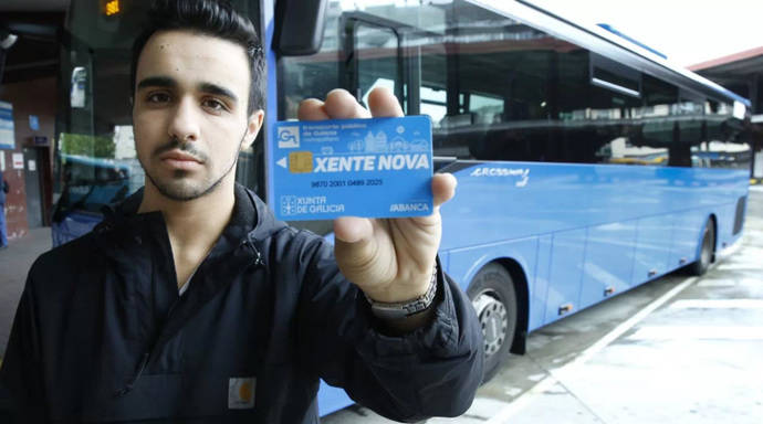 Un chico posa, delante de un autobús, con una Tarjeta Xente Nova.