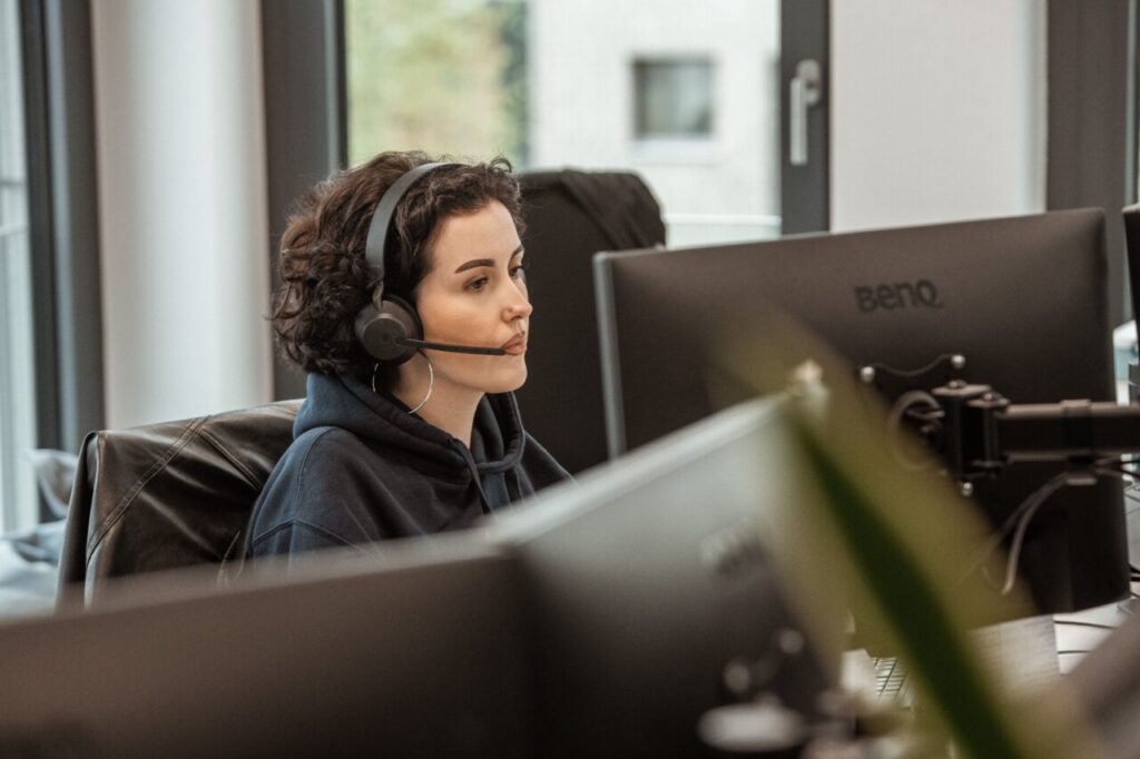 Mujer con auriculares trabajando en un entorno de oficina moderna