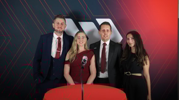 Cuatro personas vestidas de gala en un evento relacionado con camiones