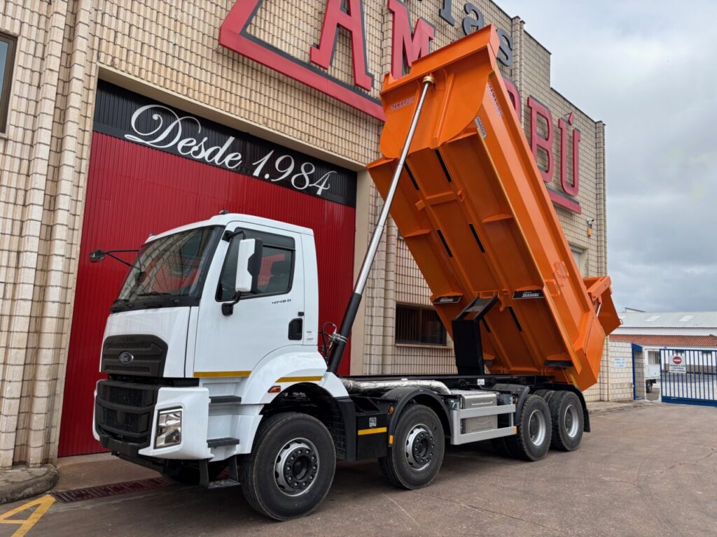 Volquete Ford Trucks en exhibición con caja volcada en evento de construcción.