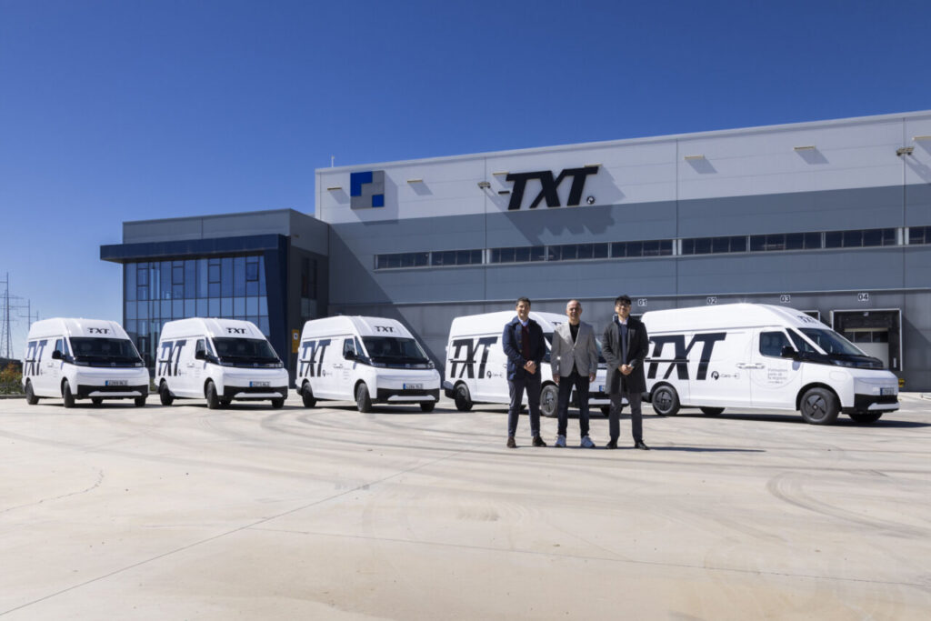 Furgonetas eléctricas de Transportes TXT en su sede con directivos