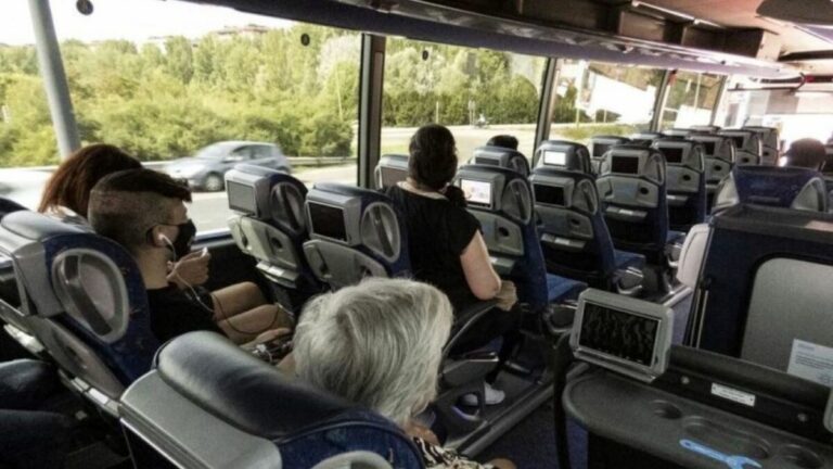 Interior de un autocar con pasajeros en un viaje urbano