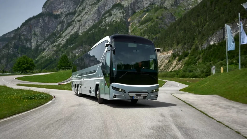 Autobús moderno circulando por una carretera en un paisaje montañoso