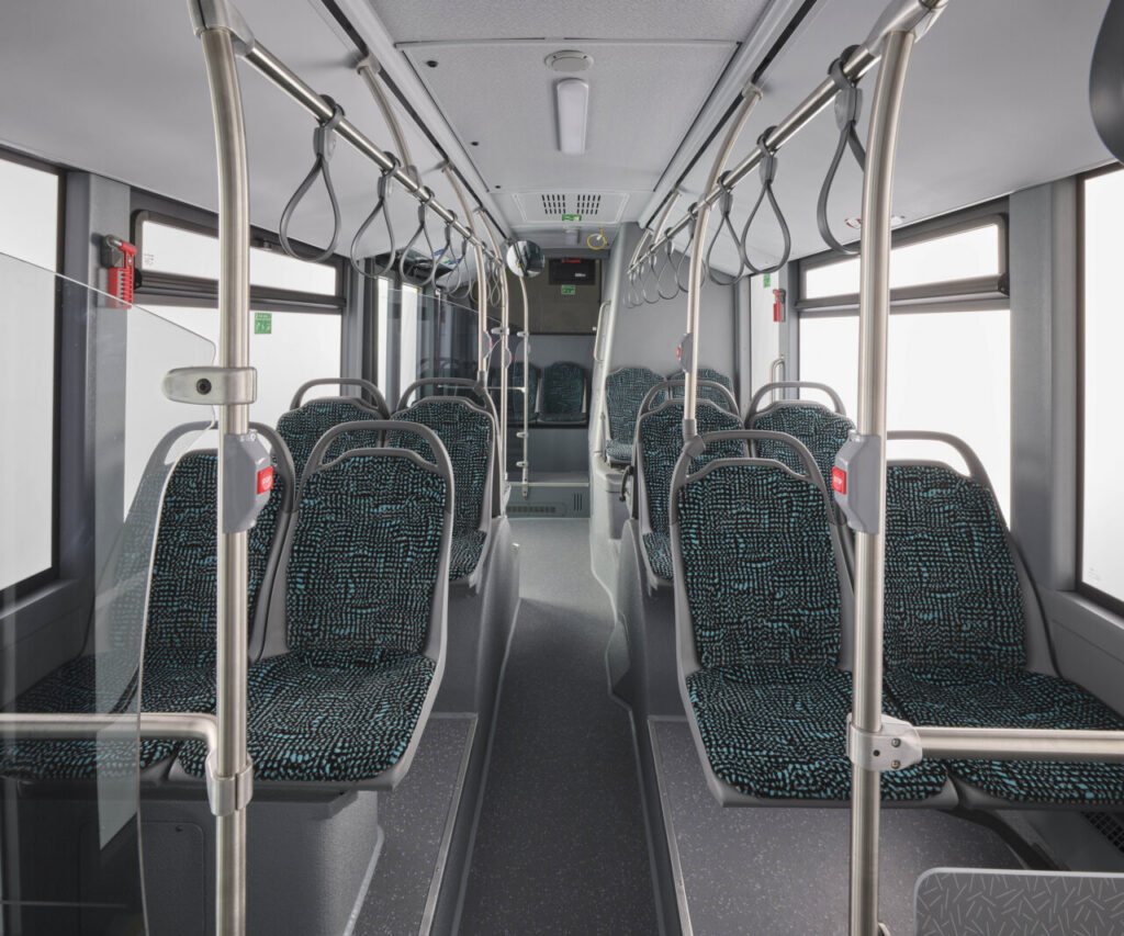 Autobús Mercedes-Benz Conecto en una calle urbana con edificios modernos.