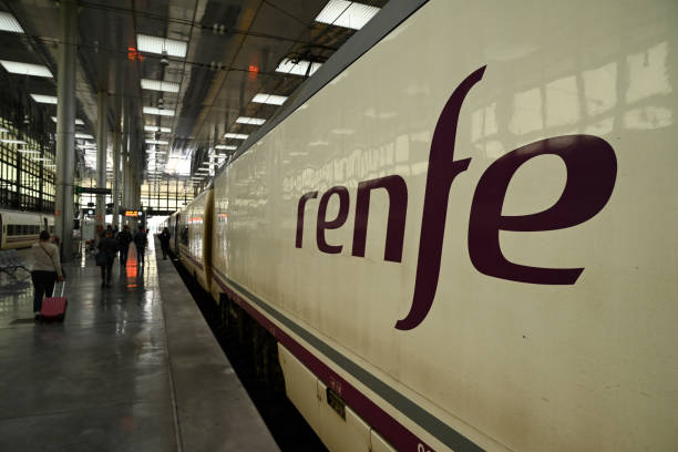 Tren de Renfe en una estación con pasajeros y equipaje