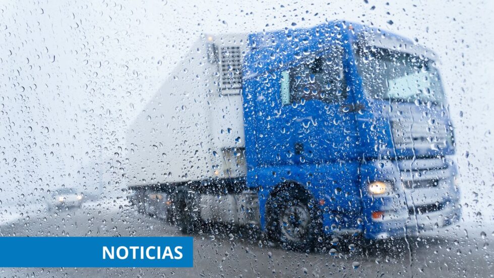 Camión azul visto a través de un cristal cubierto de gotas de lluvia.