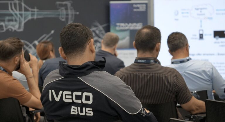 Participantes asisten a una sesión formativa de Iveco Bus frente a una pantalla.
