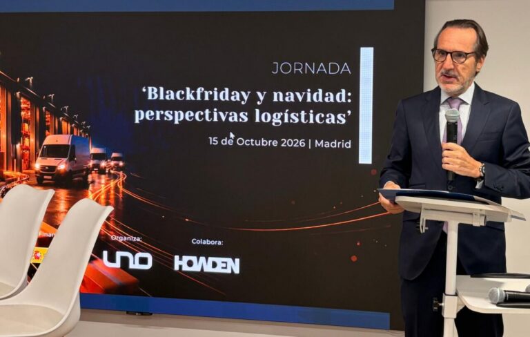 Un hombre con micrófono junto a una pantalla sobre logística en Black Friday y Navidad