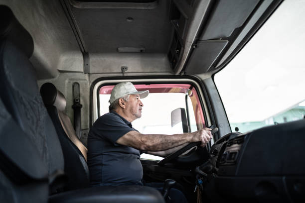 Hombre sentado al volante dentro de la cabina de un camión.