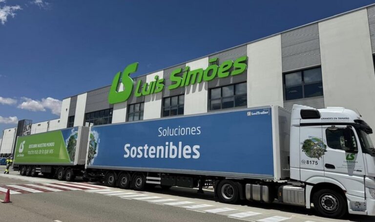 Camión de Luís Simões frente a su almacén con letrero de soluciones sostenibles