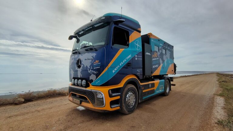 Camión eléctrico Mercedes-Benz eActros 600 adaptado, estacionado en un camino junto al agua.