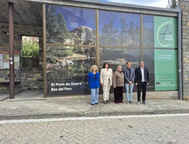 Cinco personas posan frente a un edificio con un cartel del Bus del Parc.